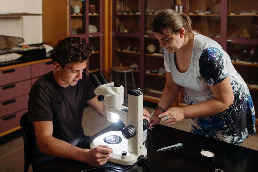 a biology student using a microscope in a laboratory